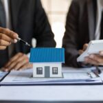 Mortgage lenders sitting around a model house