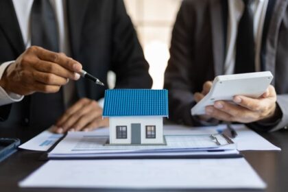 Mortgage lenders sitting around a model house