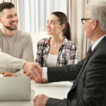 A Californian public adjuster shaking hands with a young couple.
